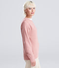 woman wearing a pink sweatshirt looking at the camera
