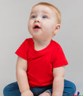 toddler wearing bright-red baby grown and blue trousers