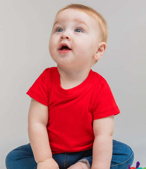 toddler wearing bright-red baby grown and blue trousers
