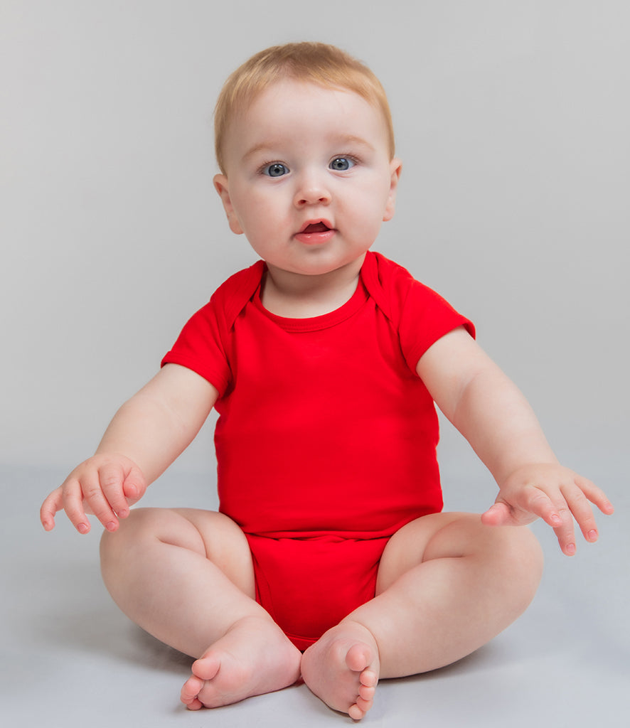 toddler wearing bright-red baby grown and blue trousers